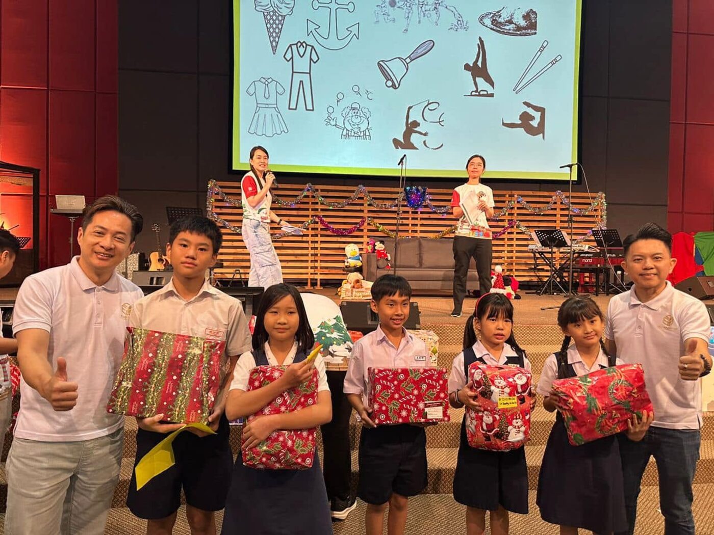 Children holding wrapped Christmas gifts at Love In Action 2024